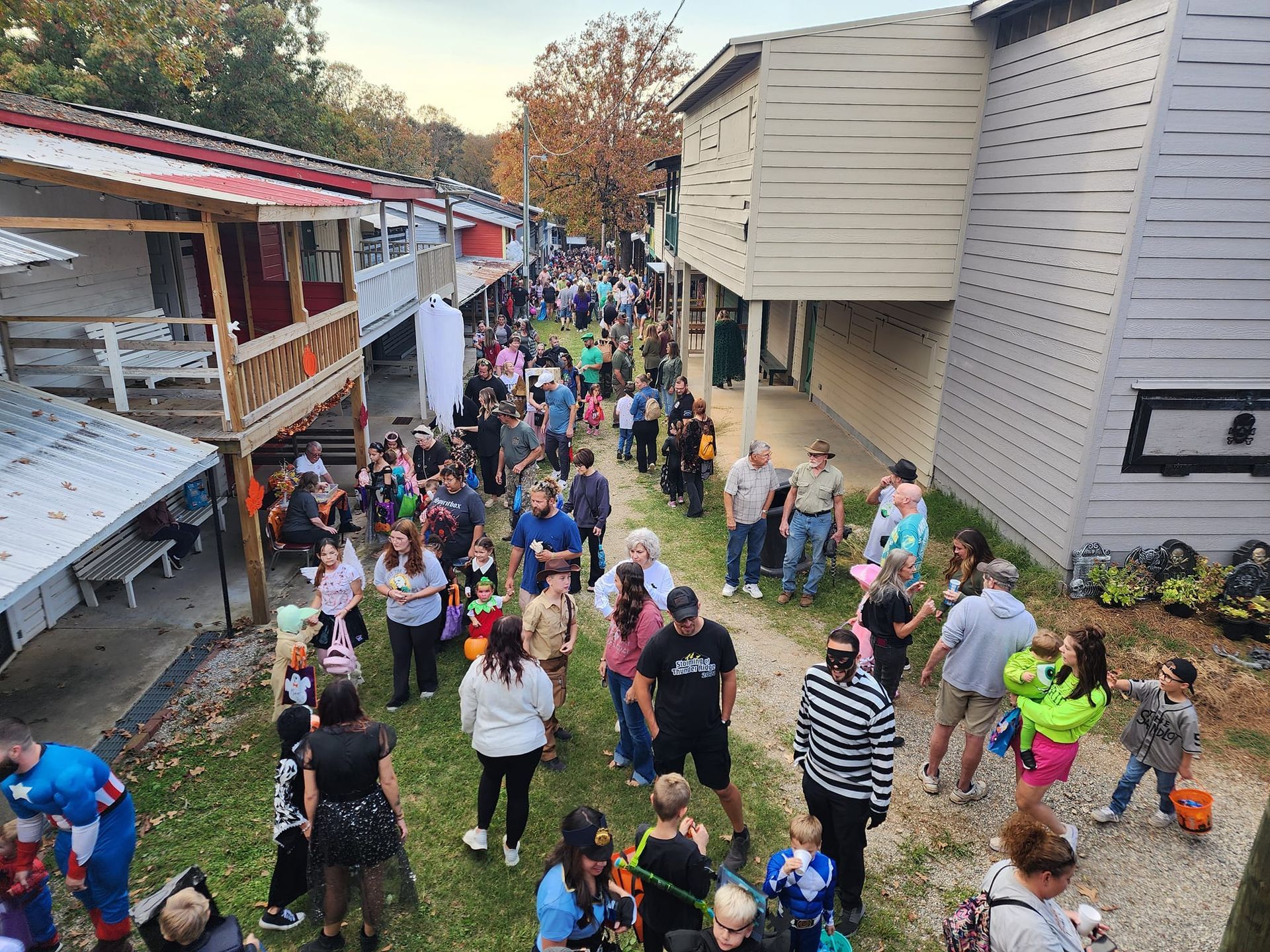 Crowd walking between buildings along a narrow path, with colorful clothes and a festive atmosphere