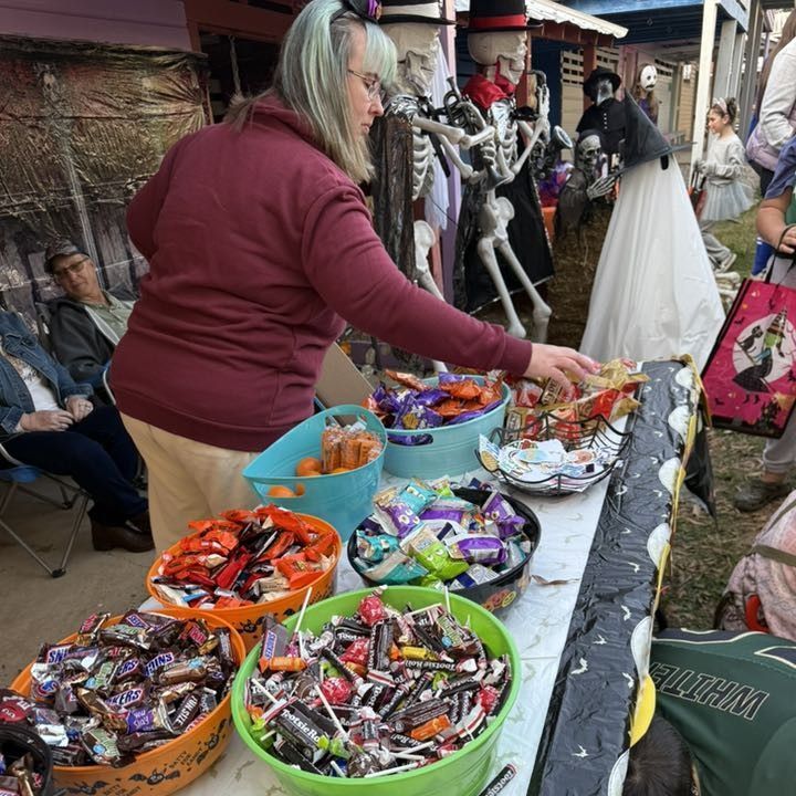 Vendor arranging candy baskets at an outdoor market stall