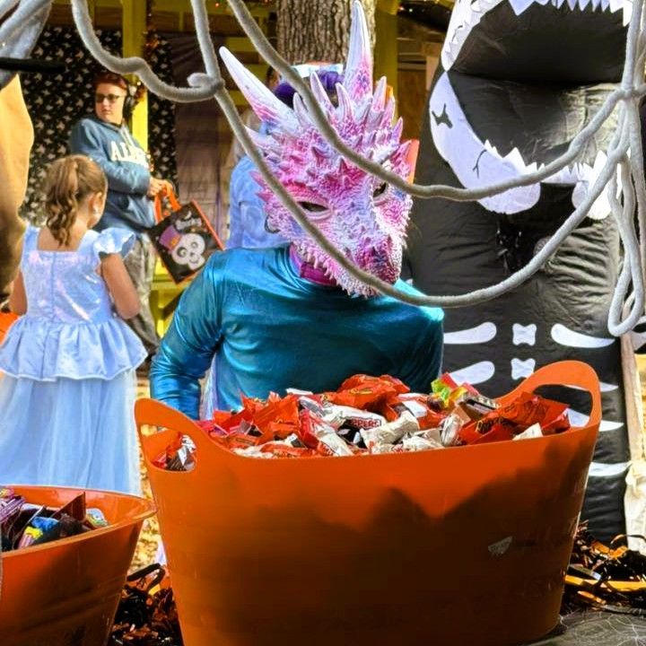 Costumed people and a child in a candy-filled Halloween parade scene