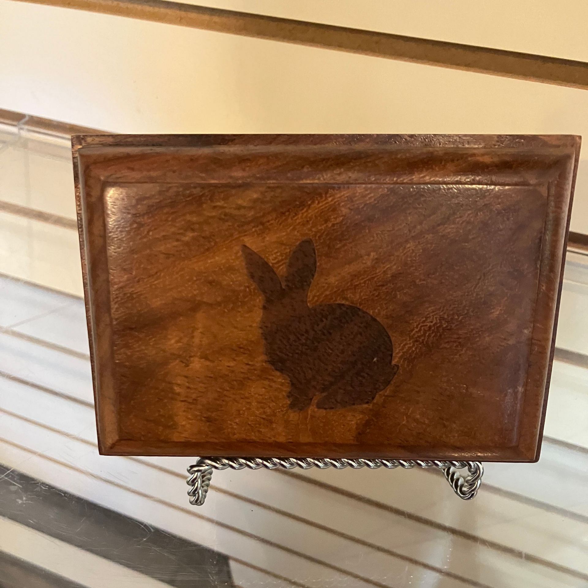 Wooden rabbit-shaped box with a dark inlay, resting on a shelf
