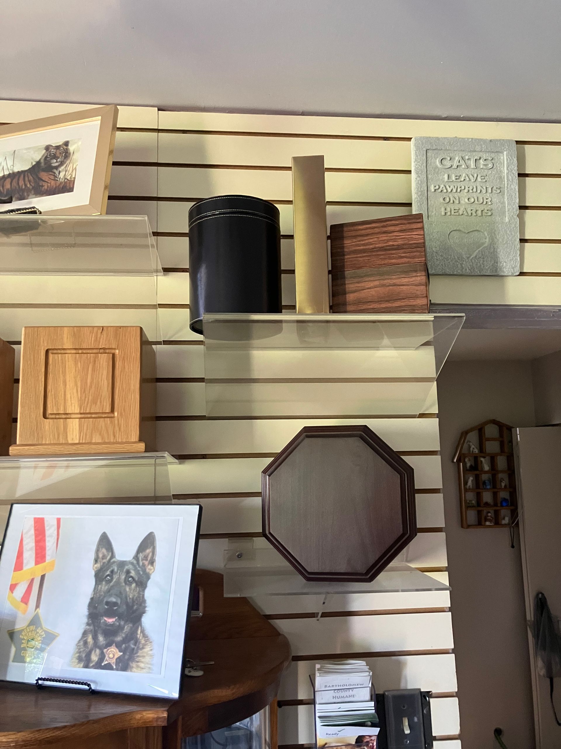 Shelves of assorted home decor and framed art on a striped wall. Shelves of assorted home decor and framed art on a striped wall.