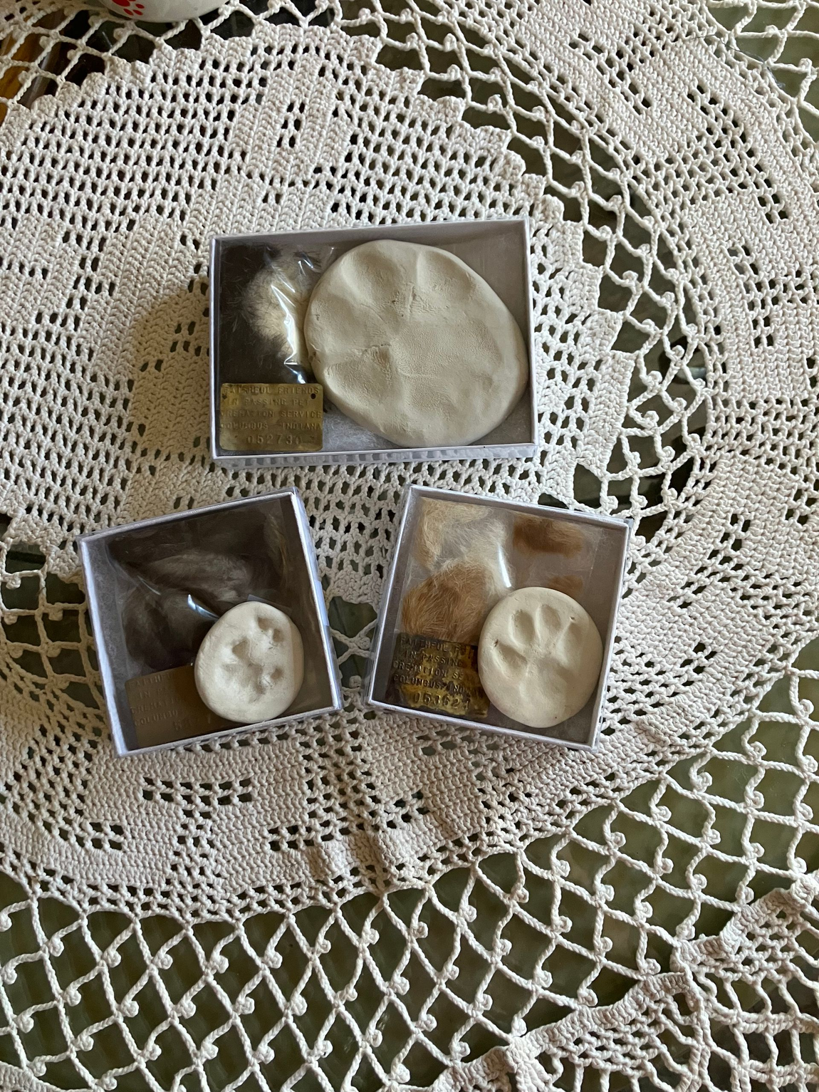 Three small square desserts with white topping on a lace doily tablecloth