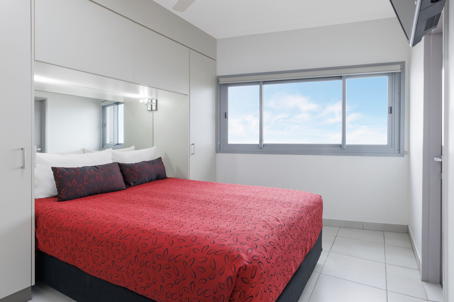 A hotel room with two beds and a window.