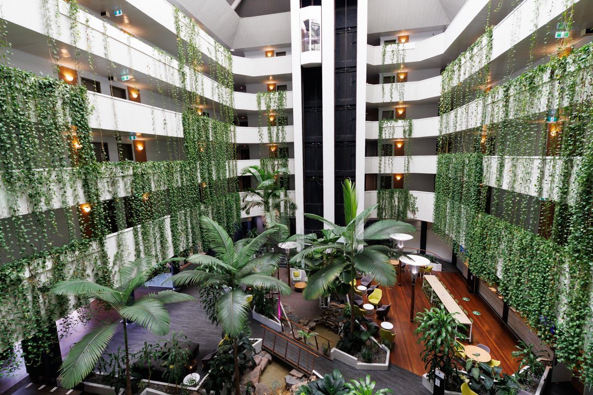 A large building with lots of plants growing on the walls