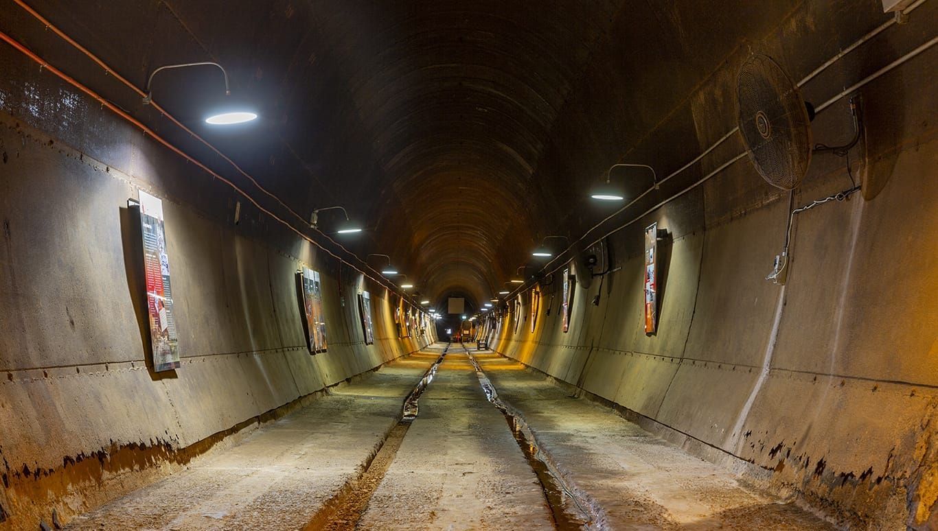 A very long tunnel with a lot of lights on the walls.
