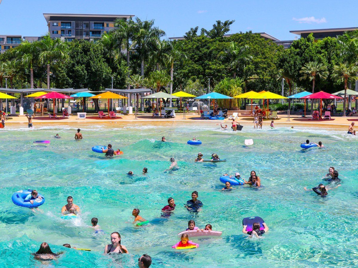 A large group of people are swimming in a large pool.