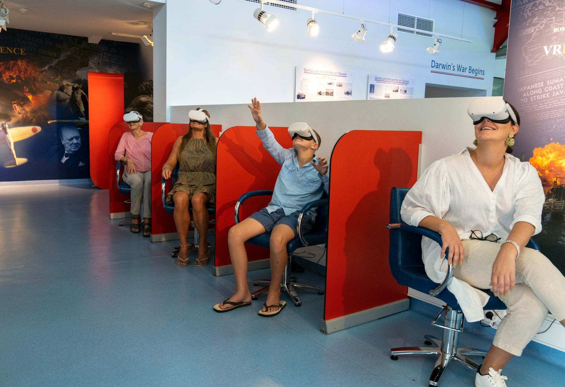 A group of people wearing virtual reality headsets are sitting in chairs.