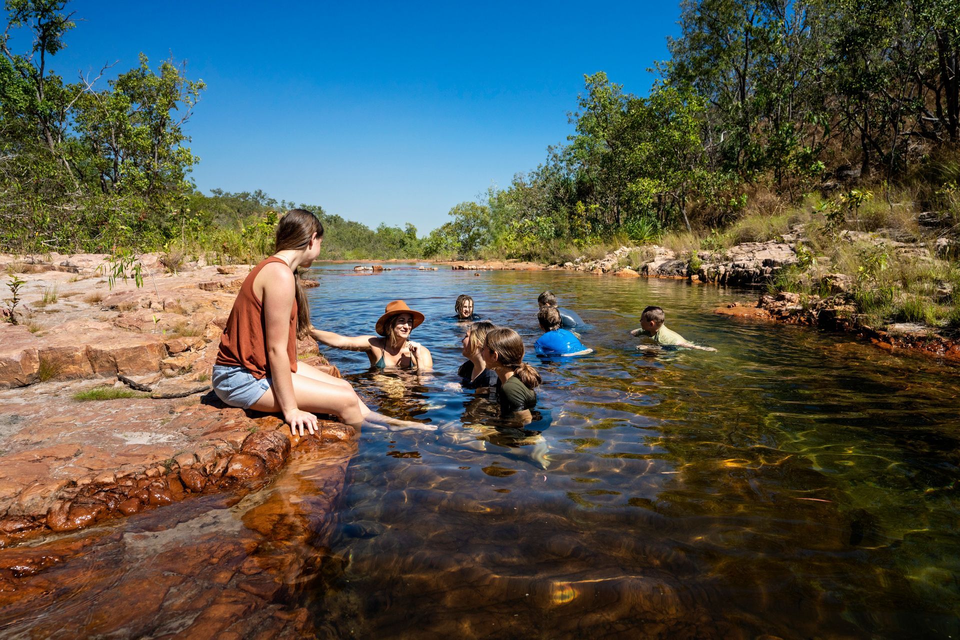 A group of people are swimming in a river.