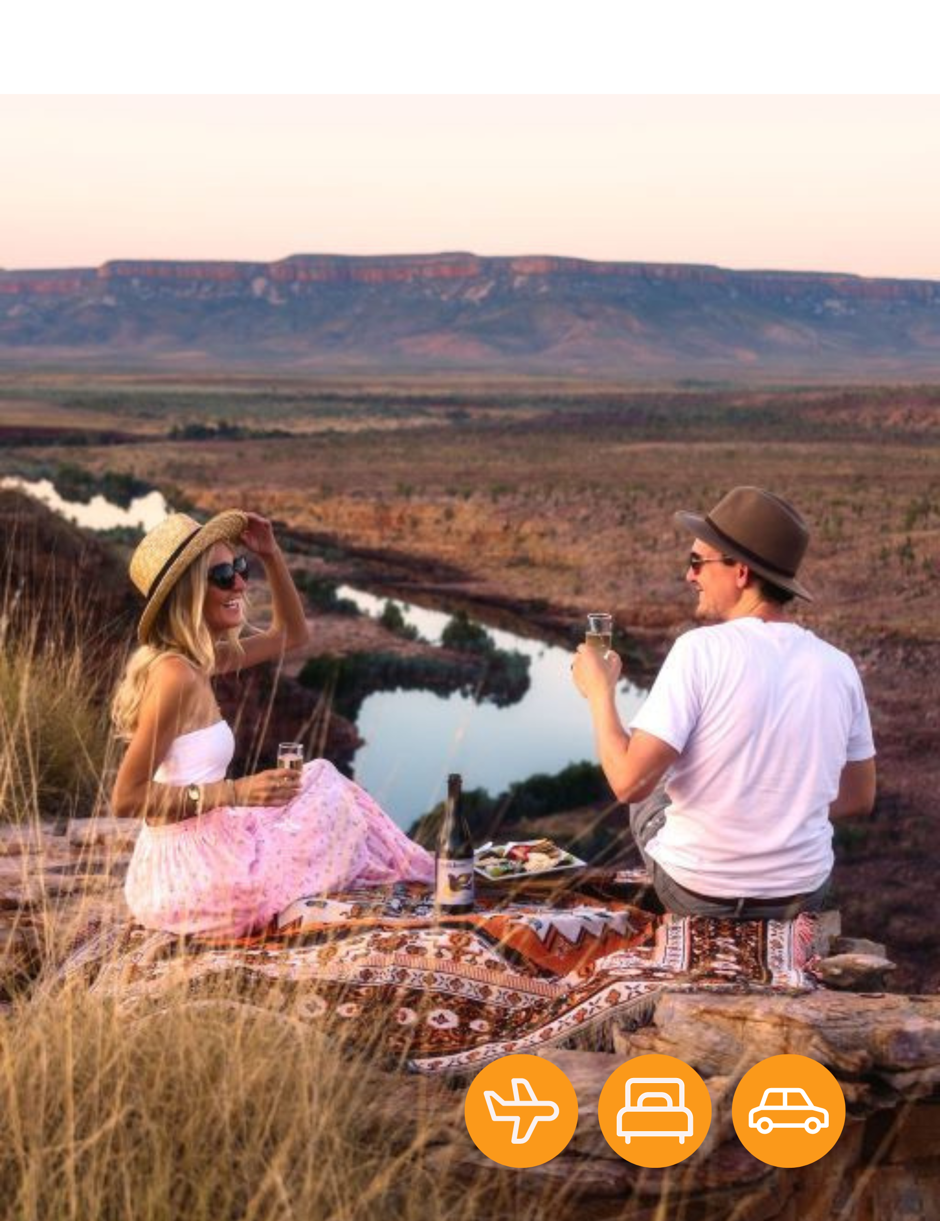 A man and a woman are having a picnic on top of a hill overlooking a river.