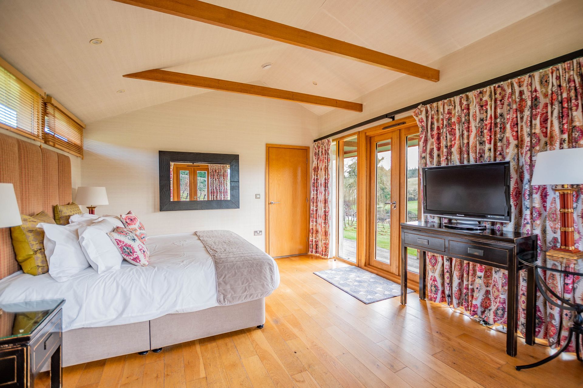 Inside the Luxury Lodge with a large bed, television, and sliding glass doors.
