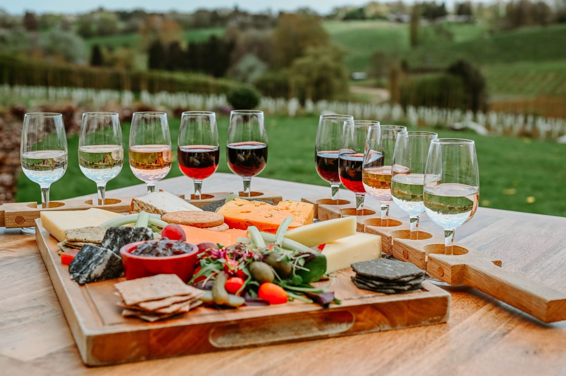 a wooden cutting board with cheese and wine glasses on it