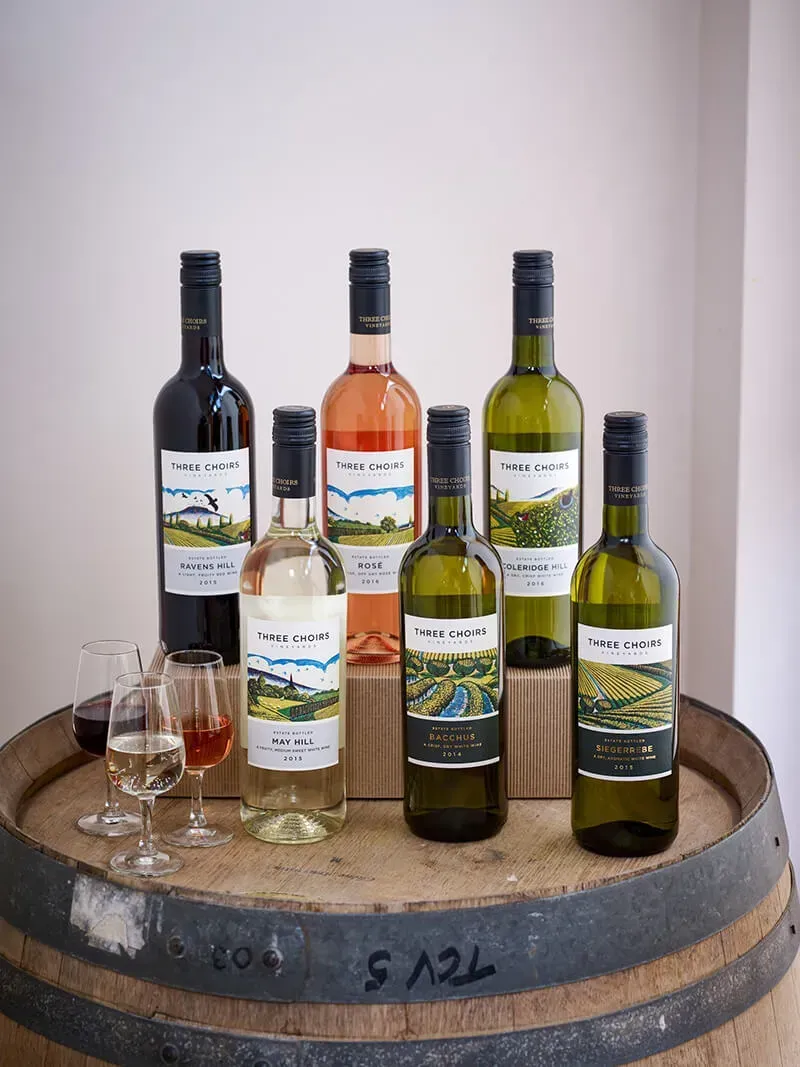 several bottles of wine are lined up on a wooden barrel