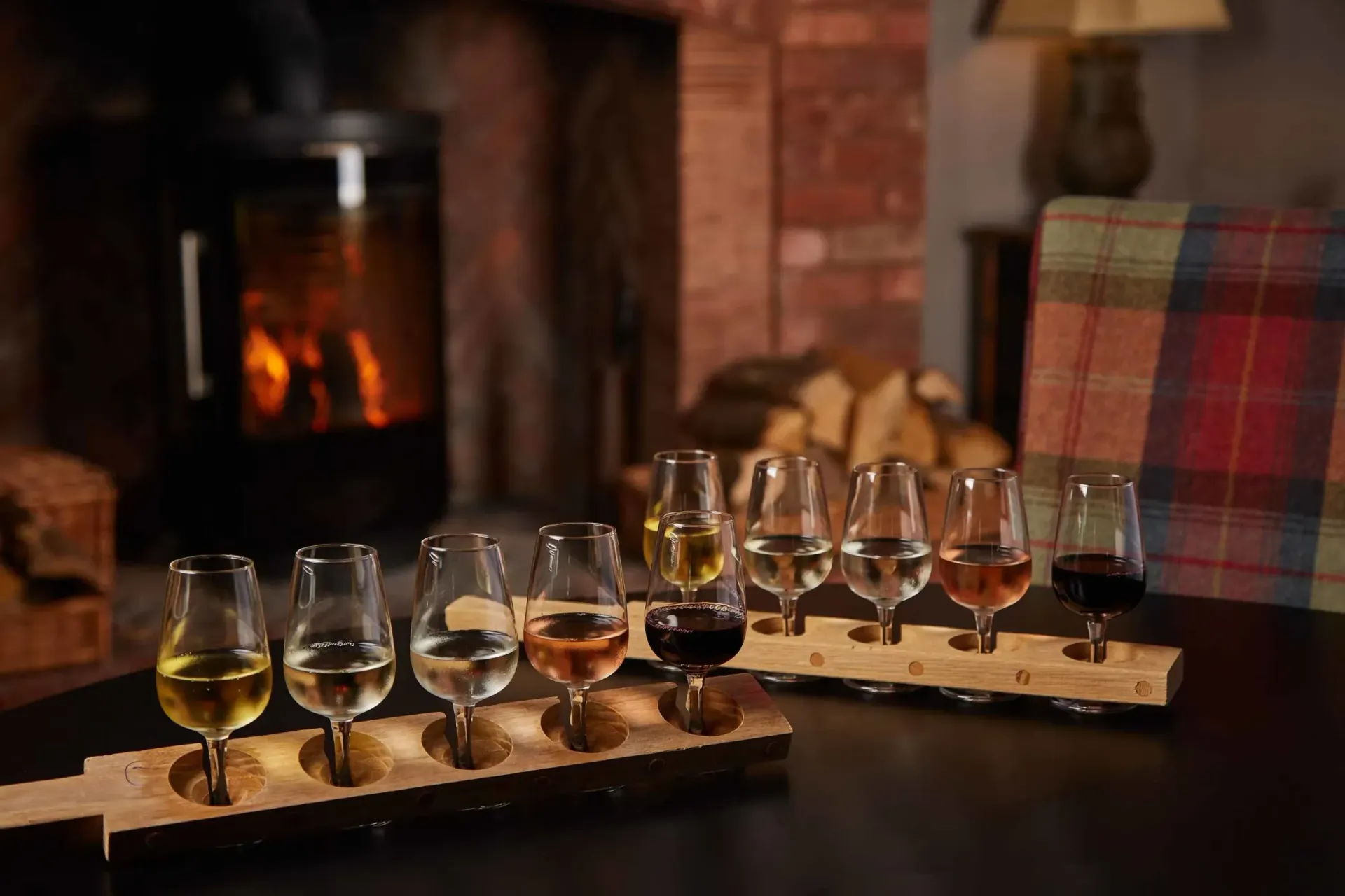 a row of wine glasses on a table in front of a fireplace