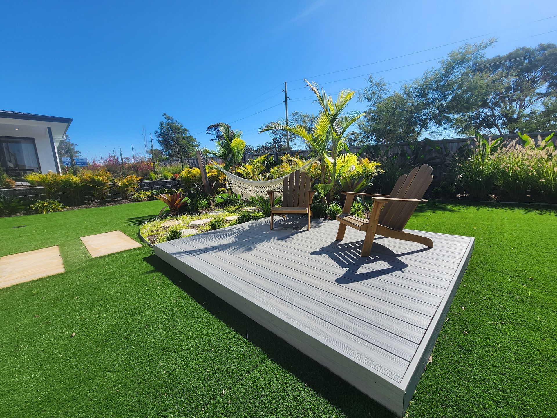 A Lush Green Lawn With A Brick Fence And A Backyard Of A House — Green Envy Landscape & Garden Services In Cameron Park NSW