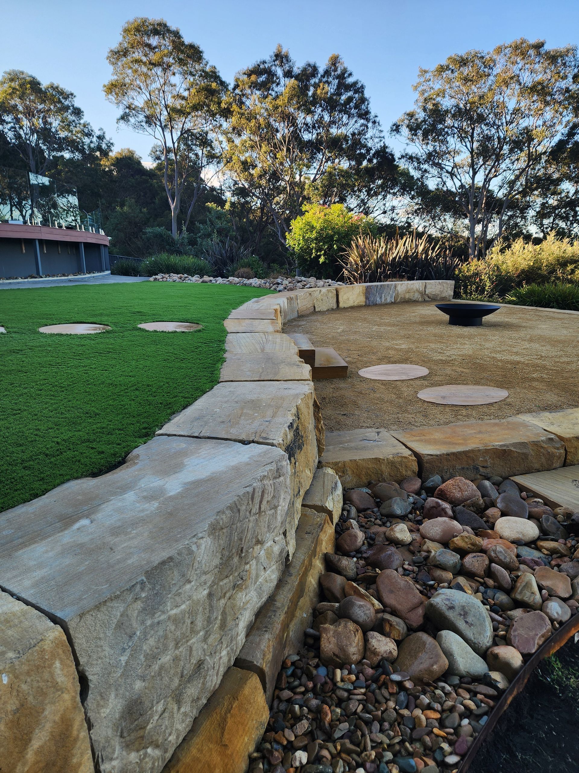 A Brick Wall With A Planter In The Middle Of It Next To A House — Green Envy Landscape & Garden Services In Cameron Park NSW
