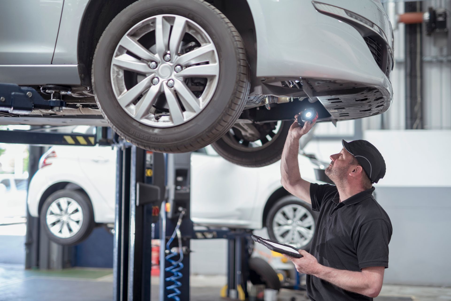 A Man Looks Under A Car — Metairie, LA — Bert's Auto Repair A Man Looks Under A Car — Metairie, LA — Bert's Auto Repair
