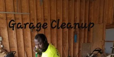 A man is standing in a garage talking on a cell phone.