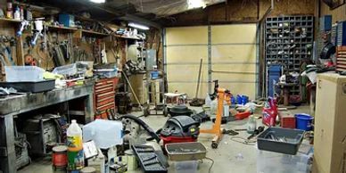 A messy garage filled with lots of tools and equipment.