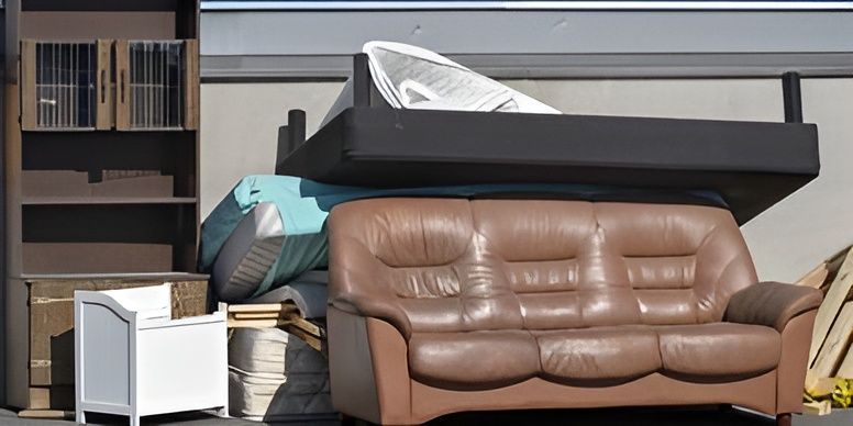 A couch is sitting on top of a pile of furniture.