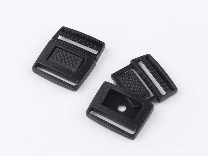 Black plastic side-release buckles, various pieces, on white background.