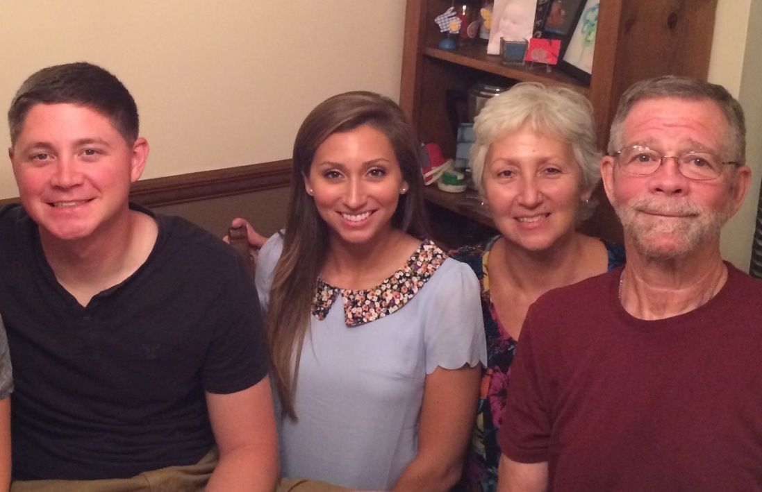 A family is posing for a picture together in a living room.