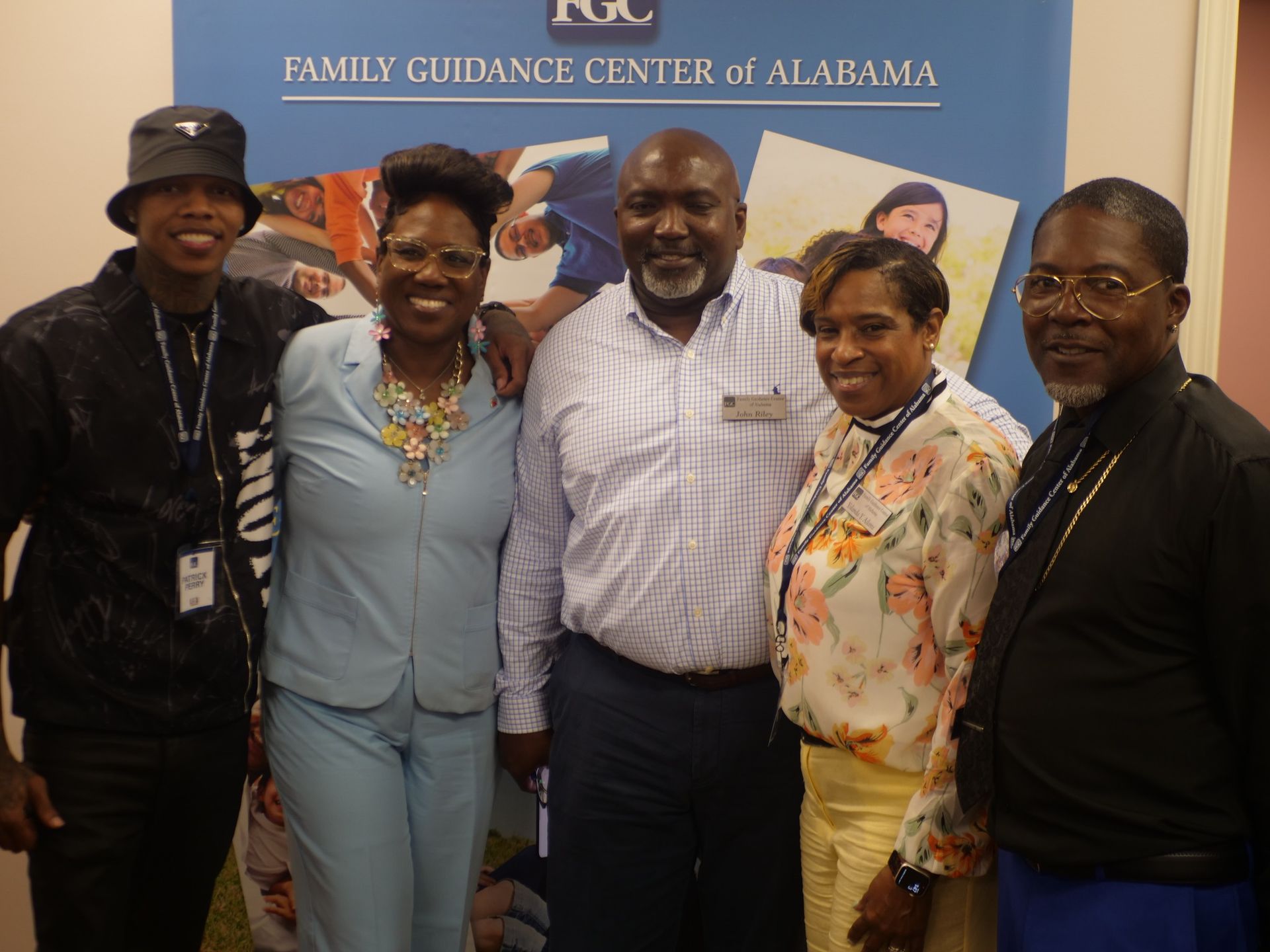 A group of people standing in front of a sign that says fgc family guidance center of alabama