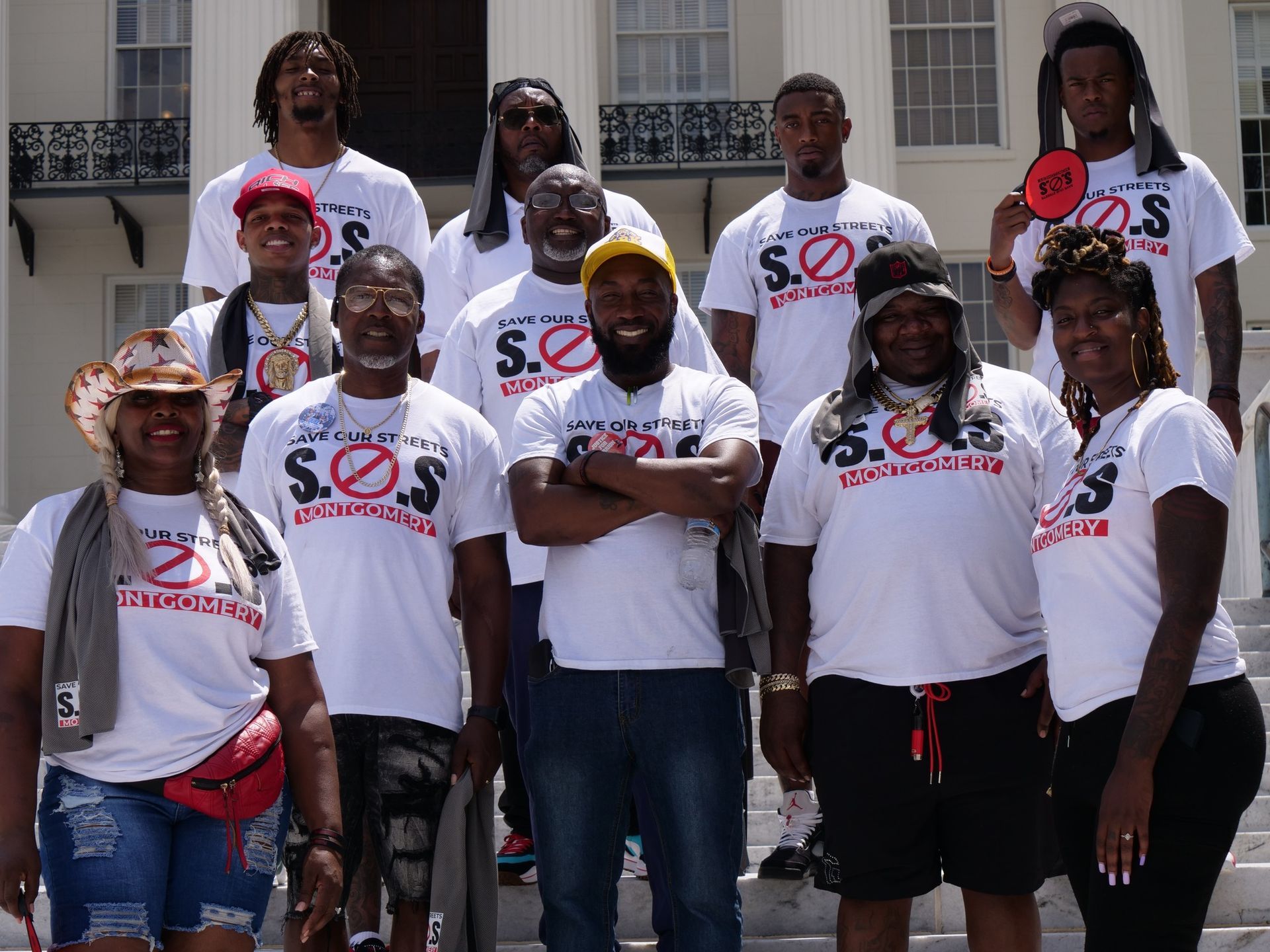 A group of people wearing sos shirts are posing for a picture