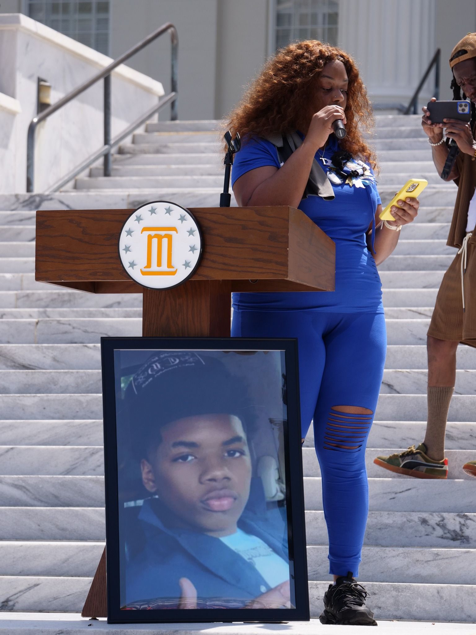 A woman stands at a podium with a picture of a boy on it