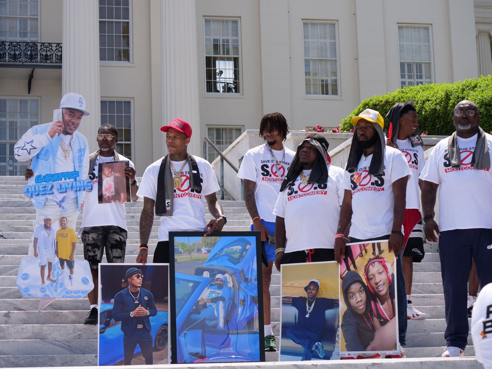 A group of people standing on a set of stairs holding pictures