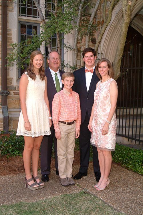 A family is posing for a picture in front of a building.