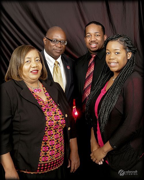 A group of people posing for a picture with a black background