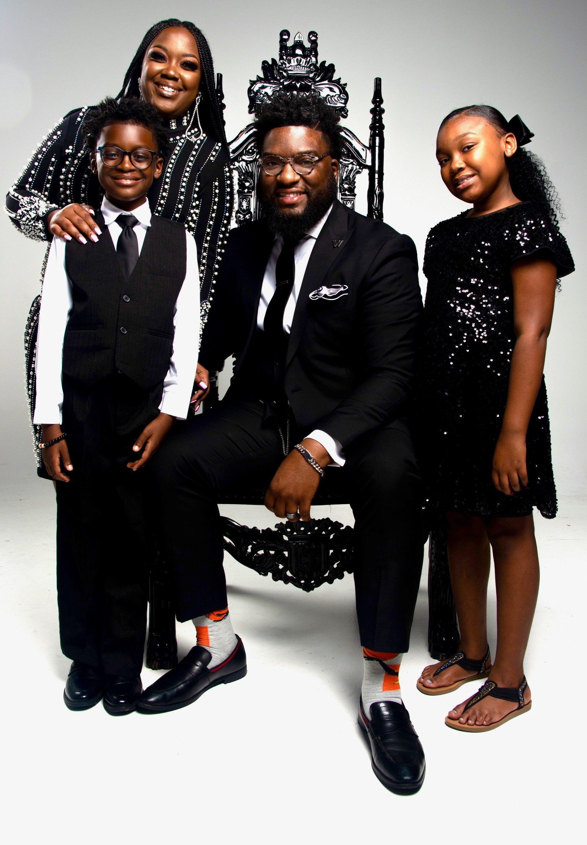 A family is posing for a picture while sitting on a throne.