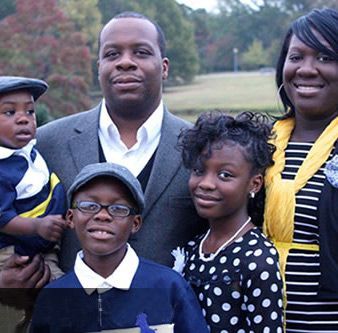A family posing for a picture with a man holding a child