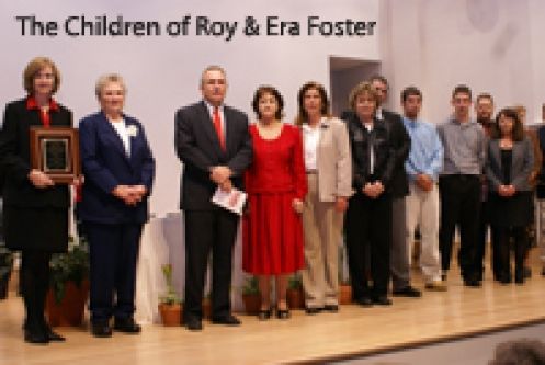A group of people standing in front of a sign that says the children of roy & era foster