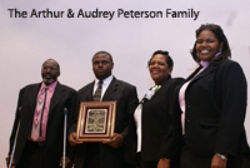 A group of people standing in front of a sign that says the arthur and audrey peterson family
