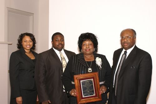 A group of people standing next to each other holding a framed picture.