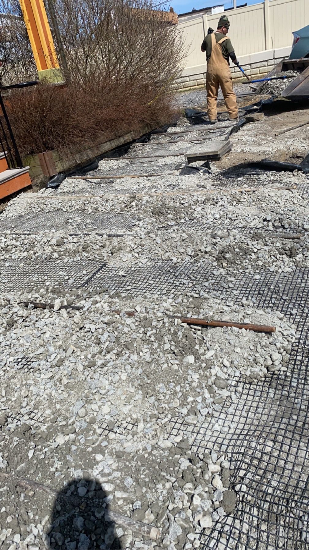 Roof under repair with torn membrane and debris, worker standing near the top.