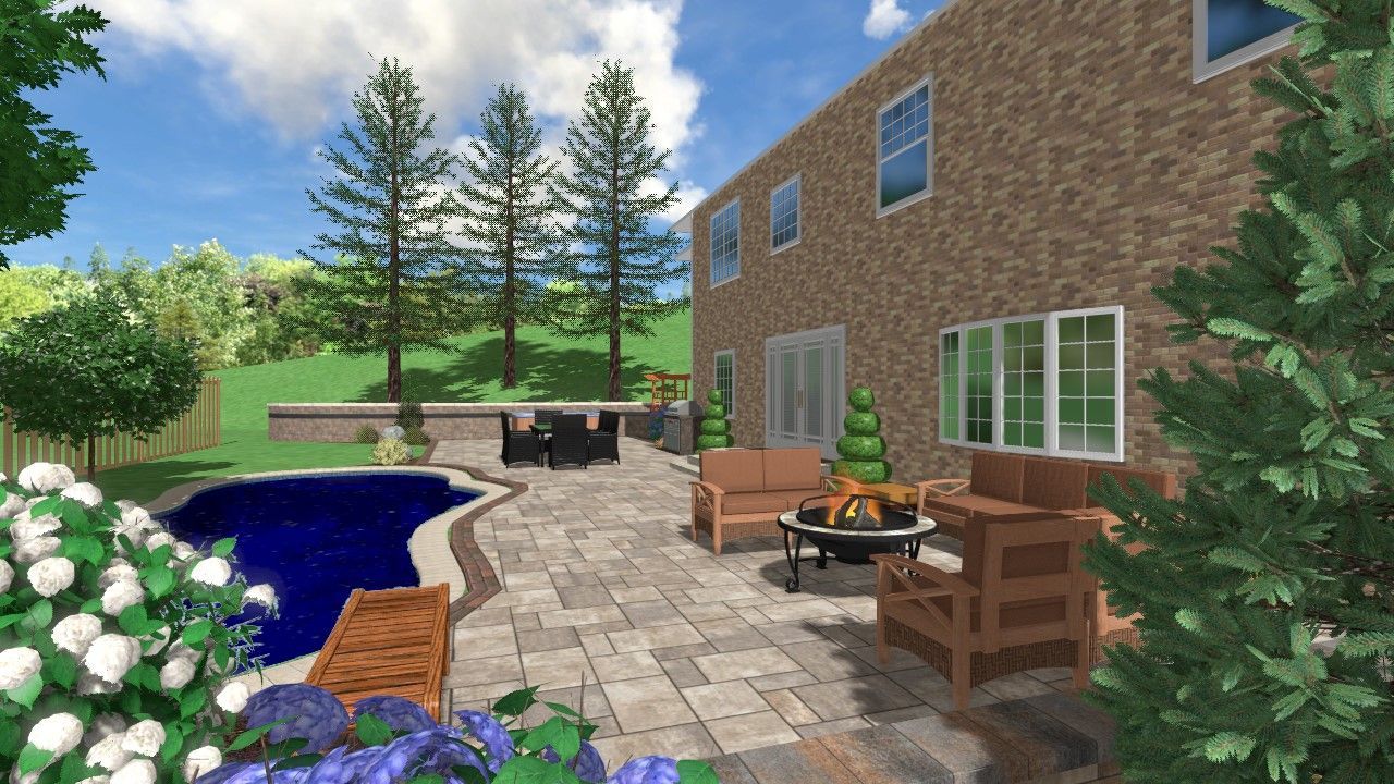 Patio with wicker furniture beside a brick house and blue pool, surrounded by flowers and trees under a sunny sky