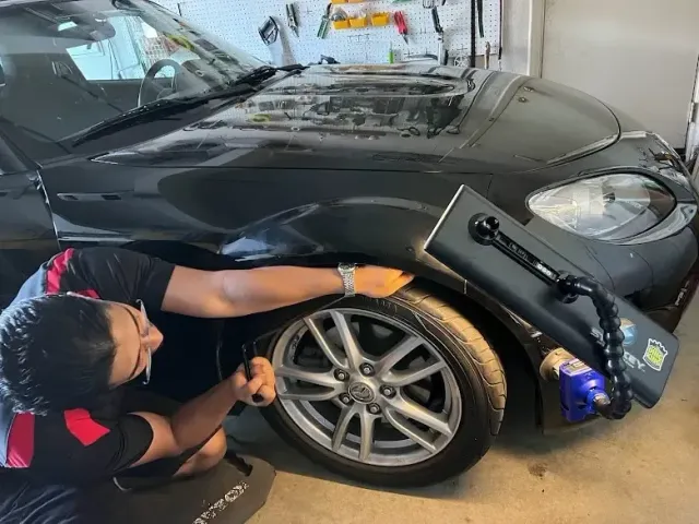 Push N Pull technician using specialized paintless dent repair tools on a vehicle fender