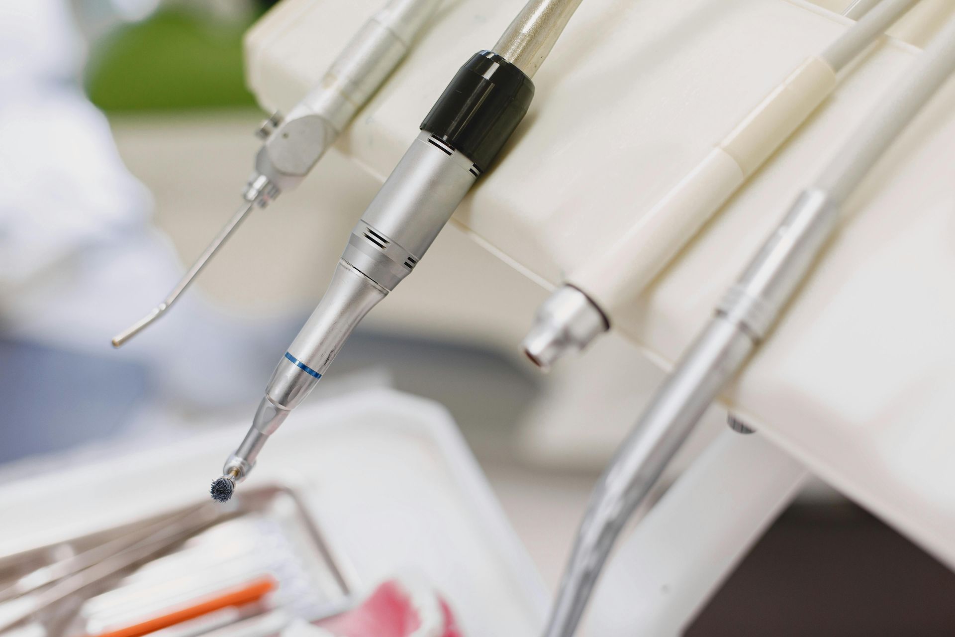 Strumenti odontoiatrici, tra cui trapani e tubi di aspirazione, in uno studio dentistico.