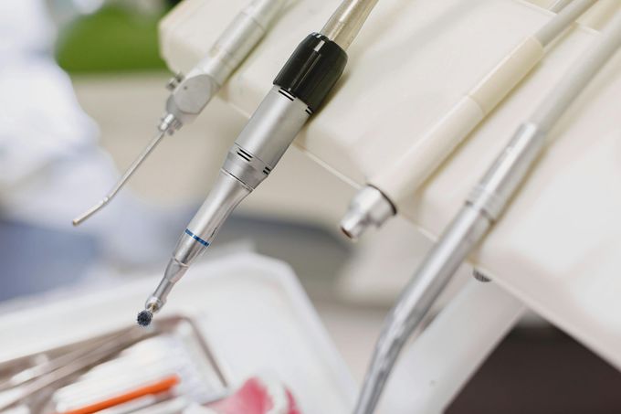 Strumenti odontoiatrici, tra cui trapani e tubi di aspirazione, in uno studio dentistico.