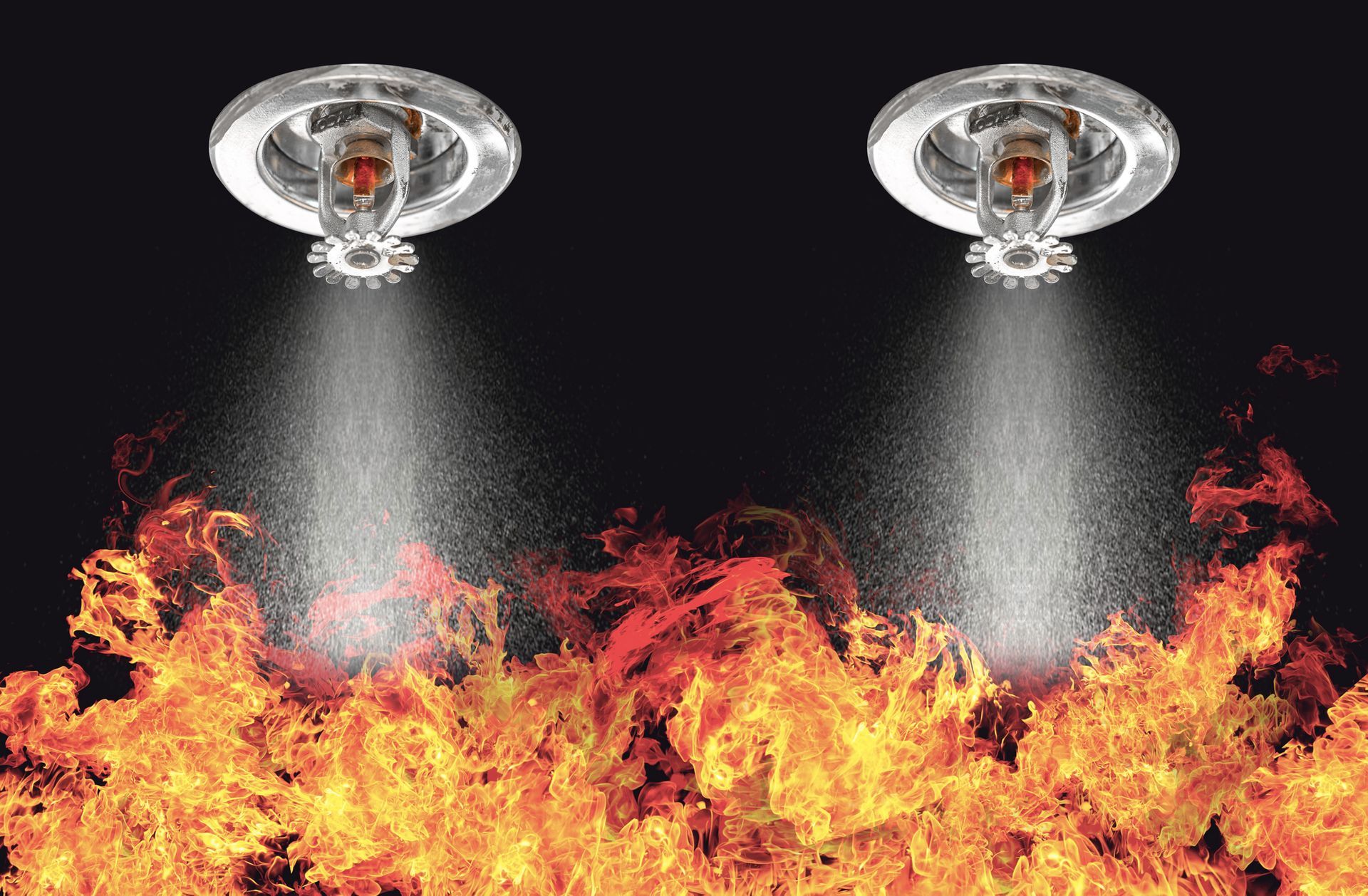 Due irrigatori antincendio spruzzano acqua su un incendio divampante.
