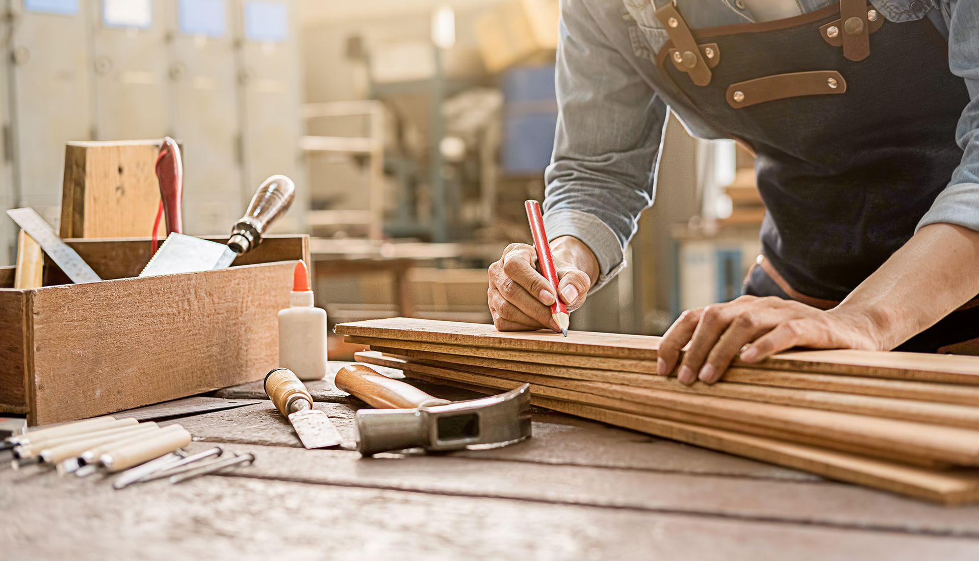 A man is measuring a piece of wood on a table.