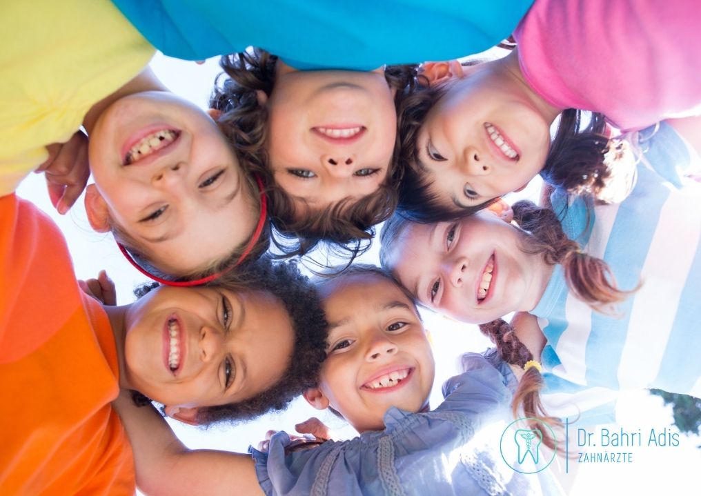 Gruppe lächelnder Kinder mit unterschiedlichen Hauttönen, die nach unten schauen, Nahaufnahme.