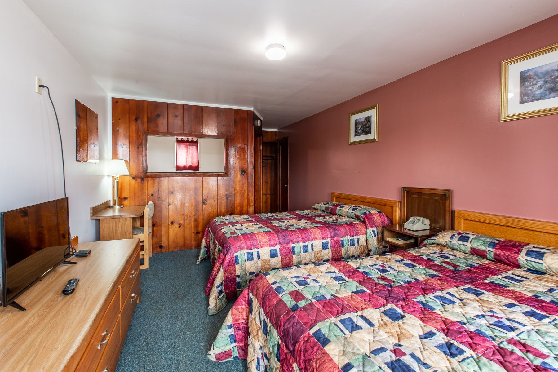 A hotel room with two beds and a flat screen tv.