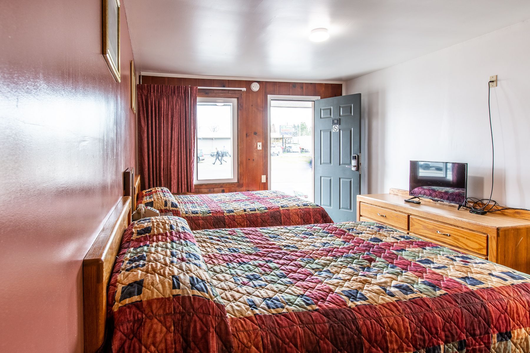 A hotel room with two beds and a television.