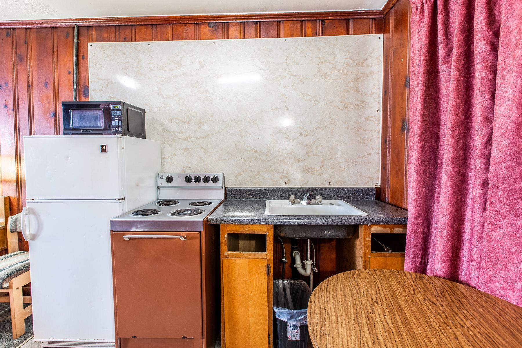 A kitchen with a refrigerator , stove , sink and microwave.