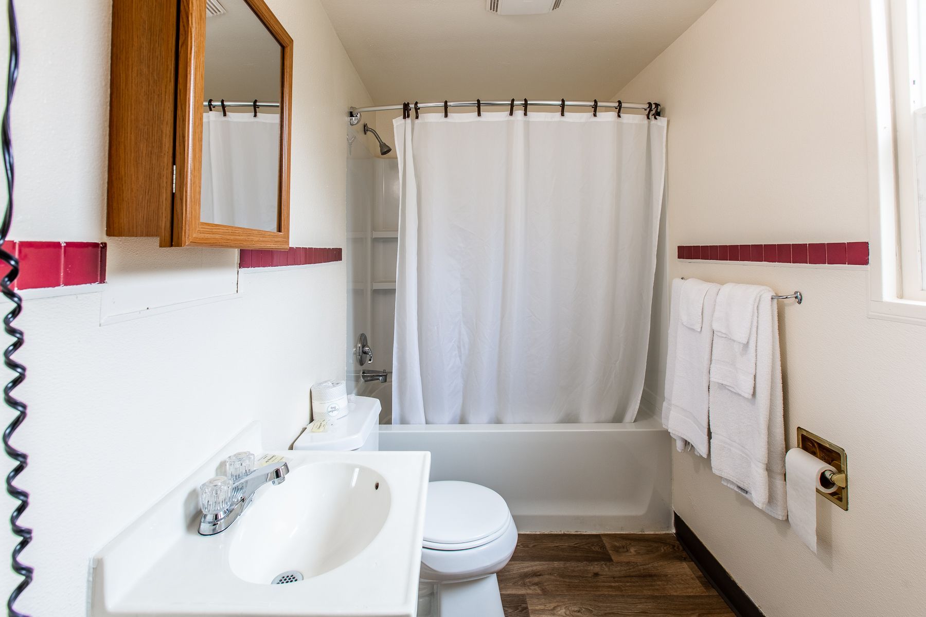 A bathroom with a sink , toilet , bathtub and mirror.
