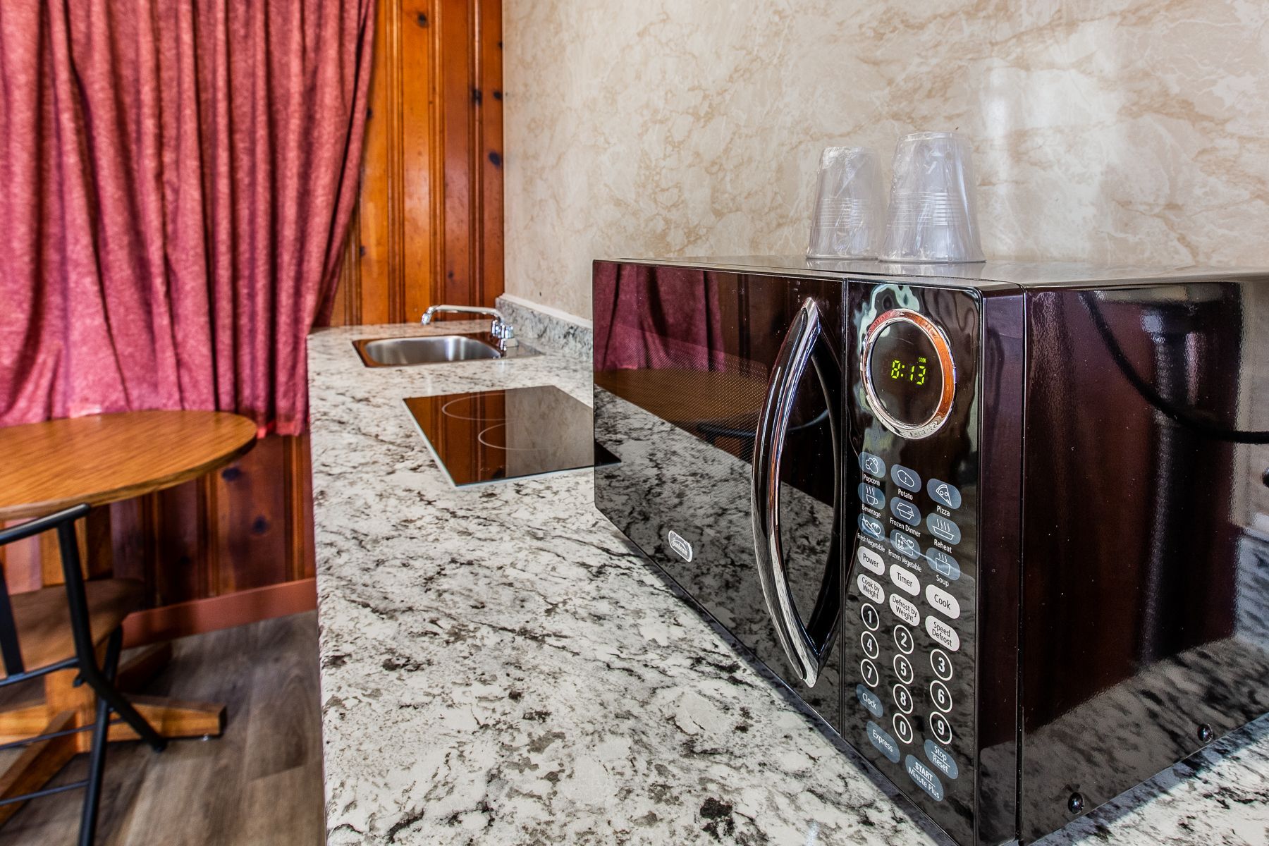 A microwave oven is sitting on top of a granite counter in a kitchen.