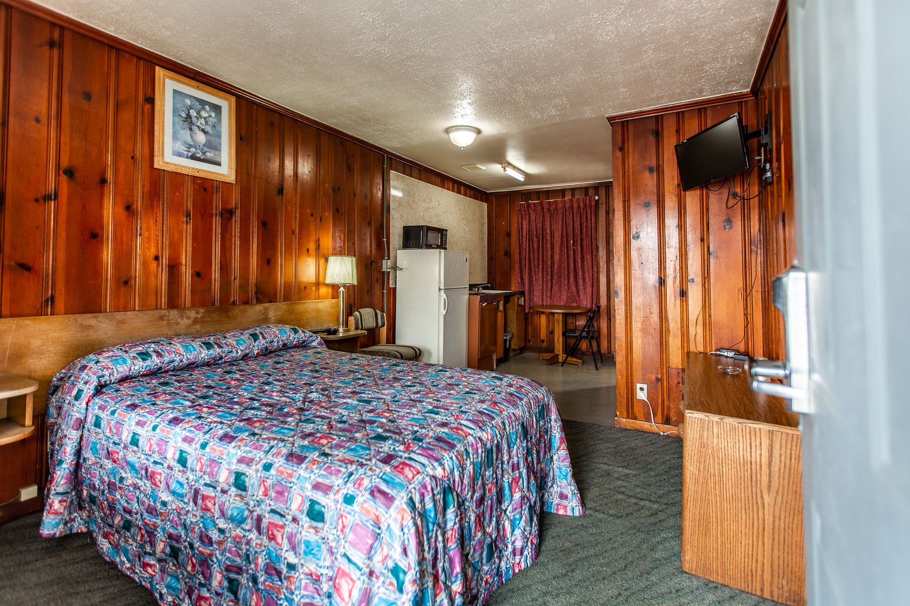 A hotel room with a king size bed and a television.
